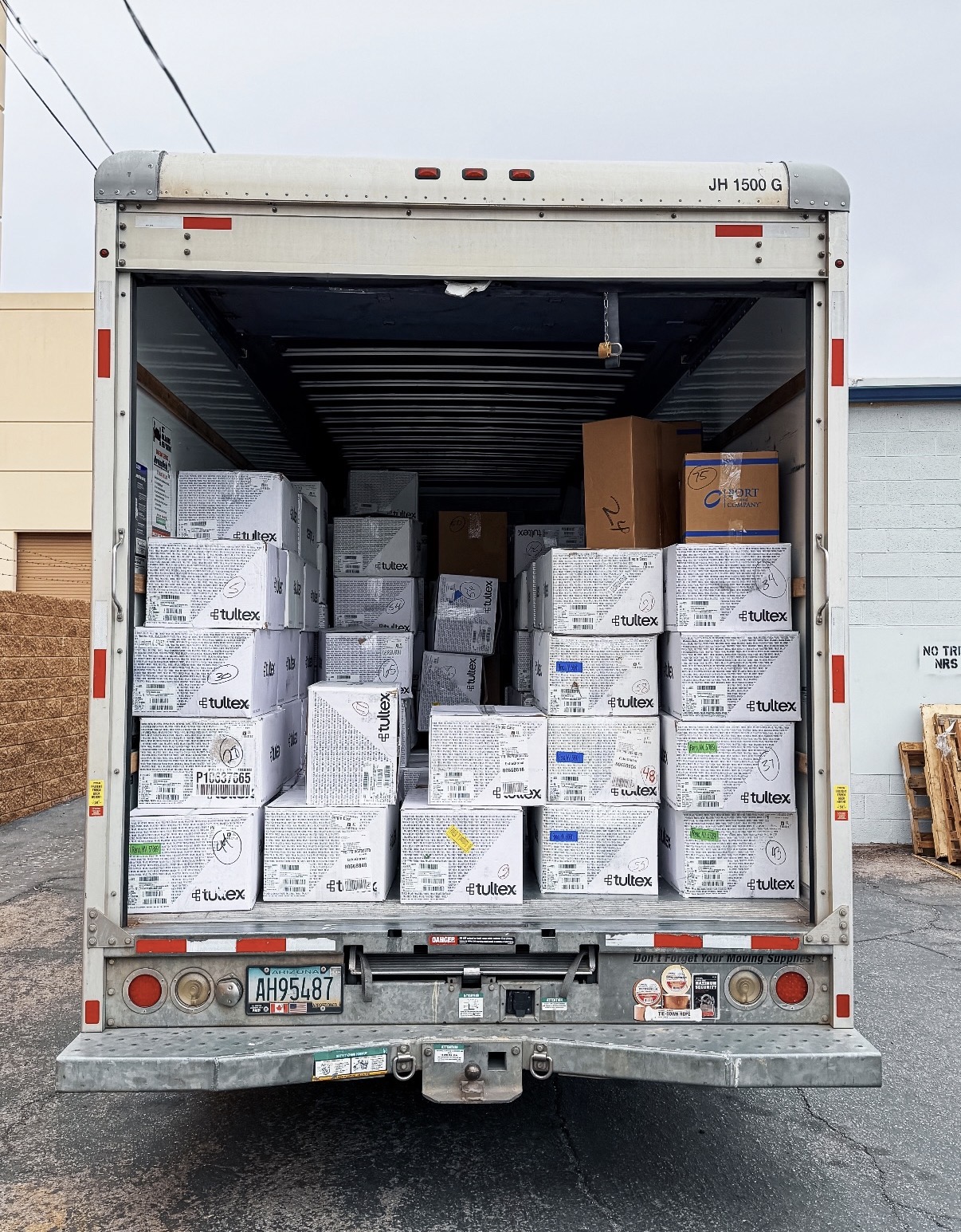Shrink-wrapped pallets of finished garments staged for blind drop-shipping